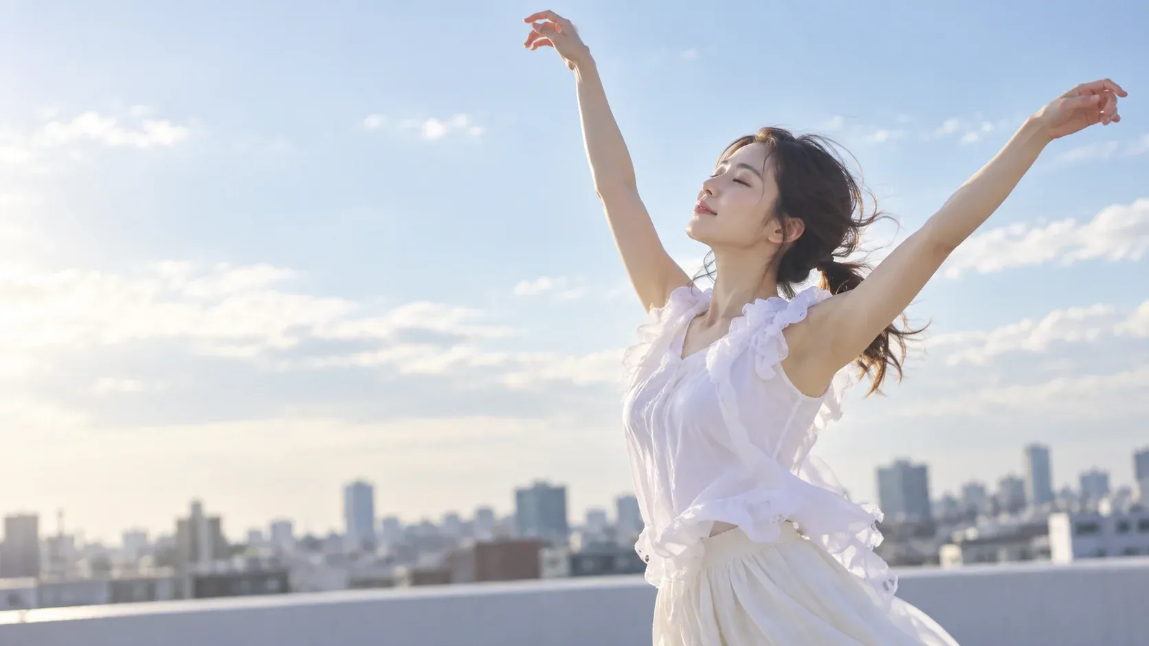青空へ両腕を伸ばし、屋上で伸びやかに踊る女性のイメージ